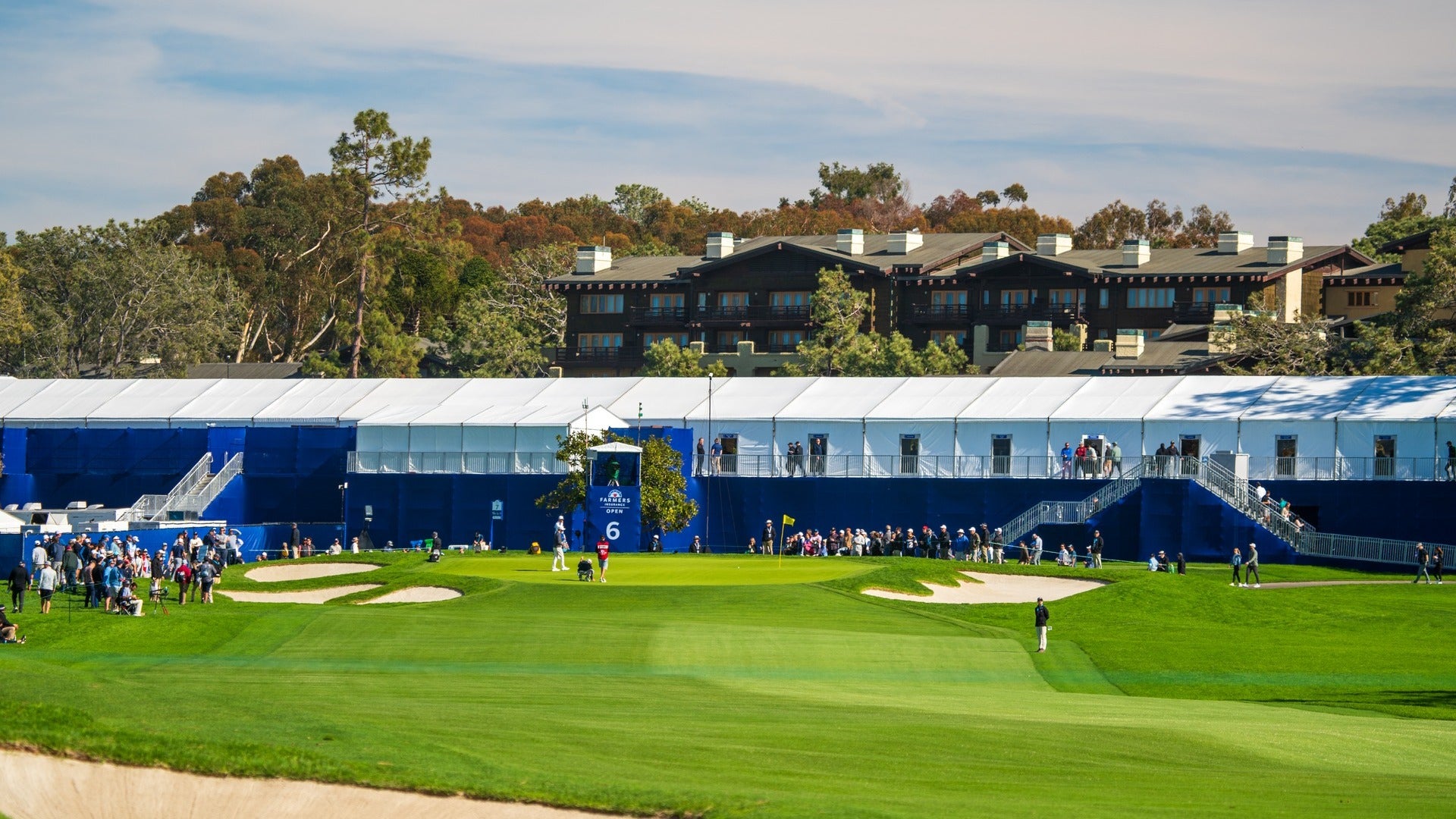 people on a golf course with view of hotel at the back